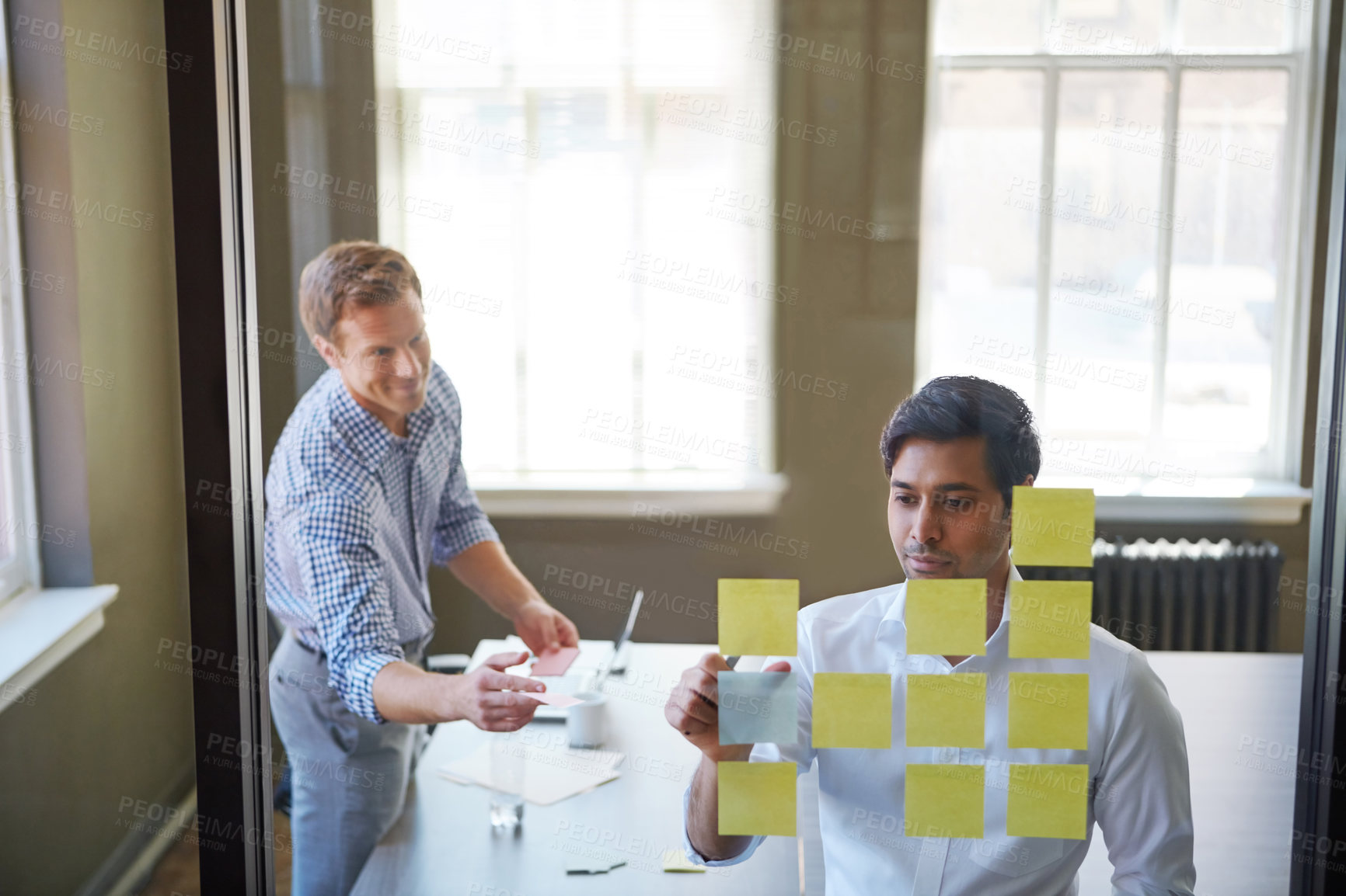 Buy stock photo Cropped shot of two businessmen preparing for a presentation by using adhesive notes