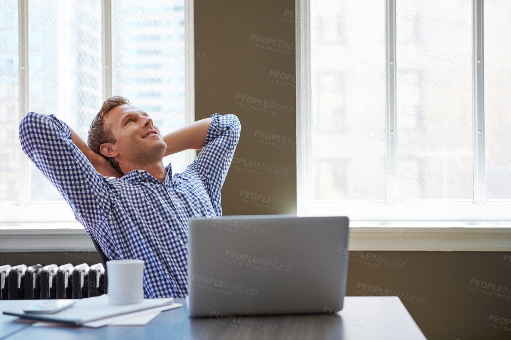 Buy stock photo Shot of a happy businessman leaning back in his chair