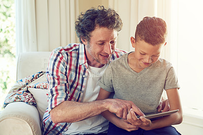Buy stock photo Cropped shot of a father and his son using a tablet together at home