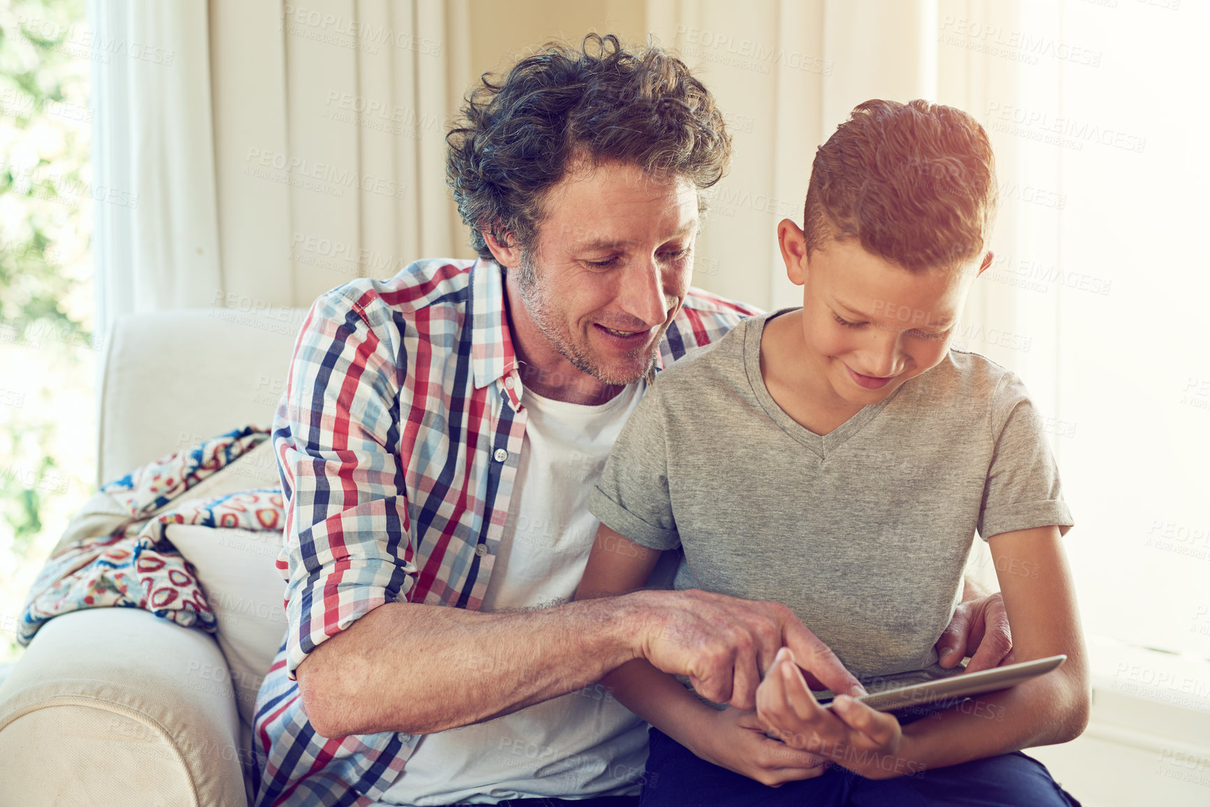 Buy stock photo Cropped shot of a father and his son using a tablet together at home