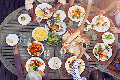 Buy stock photo High angle shot of a family eating lunch outdoors