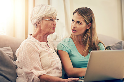 Buy stock photo Shot of a woman showing her elderly mother how to use a laptop at home