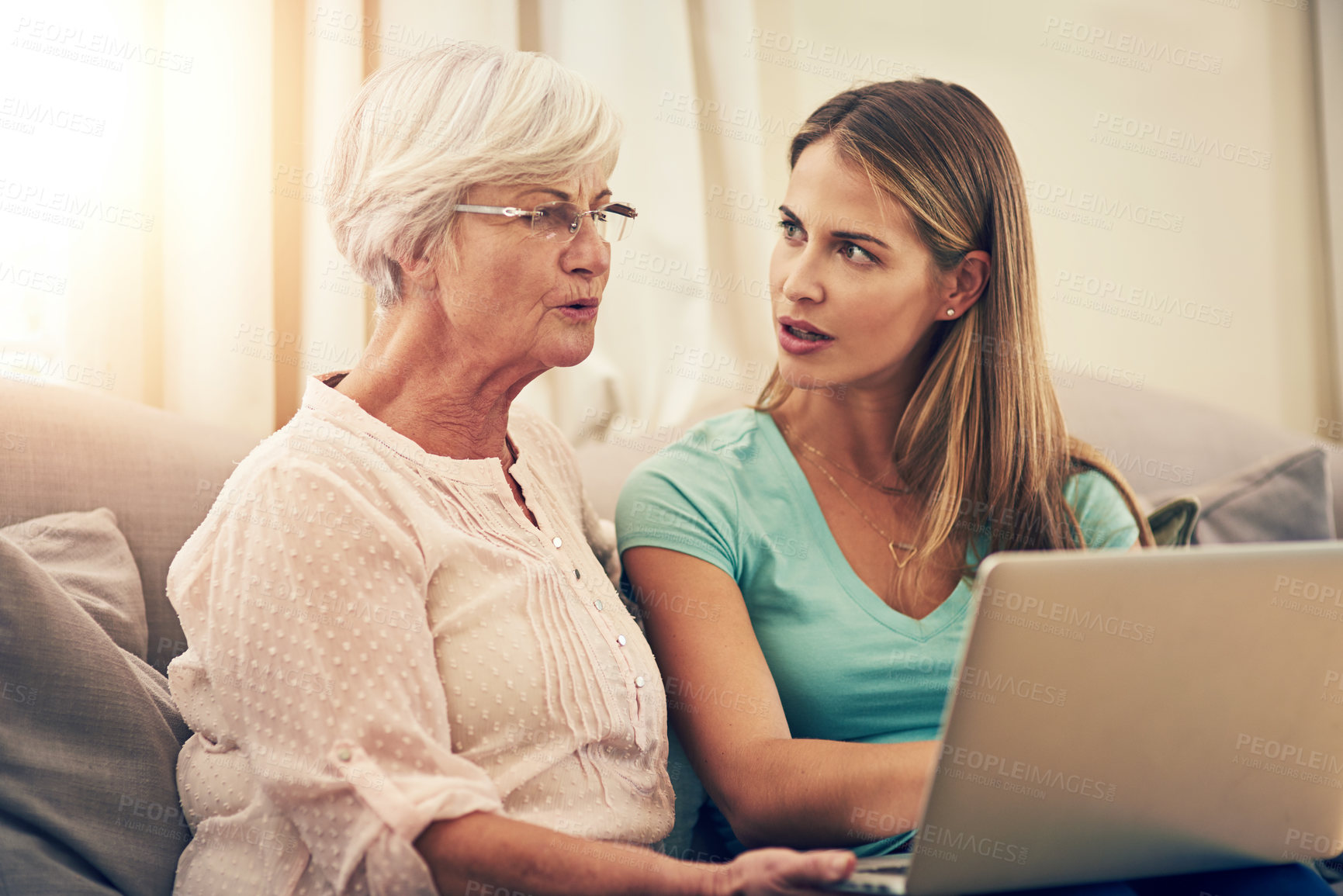 Buy stock photo Shot of a woman showing her elderly mother how to use a laptop at home
