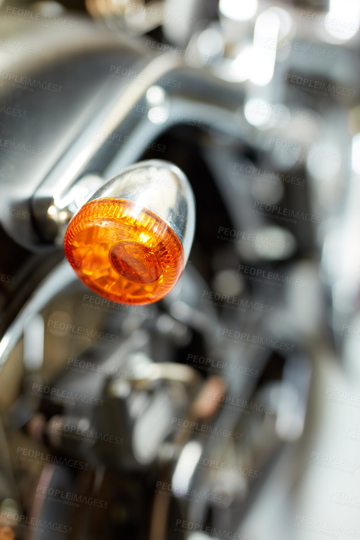 Buy stock photo Closeup rear view of a taillight on a motorbike. Orange turning light on a blurred black vintage motorcycle. One modern chrome transportation vehicle. Maintenance on a shiny classic retro custom bike