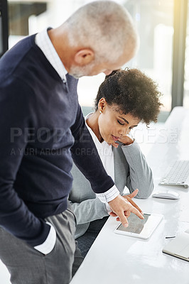 Buy stock photo Shot of a mature businessman showing his colleague something on a tablet