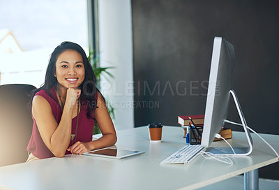 Buy stock photo Portrait of a confident young businesswoman sitting at a desk in a modern office