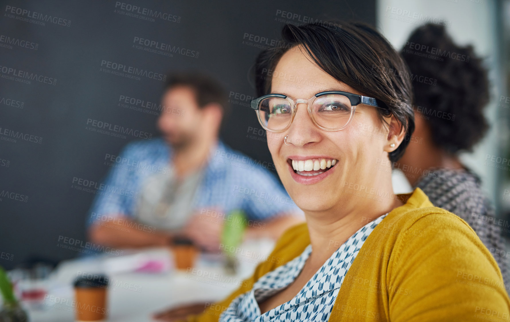 Buy stock photo Portrait of a young businesswoman in an office meeting with colleagues in the background