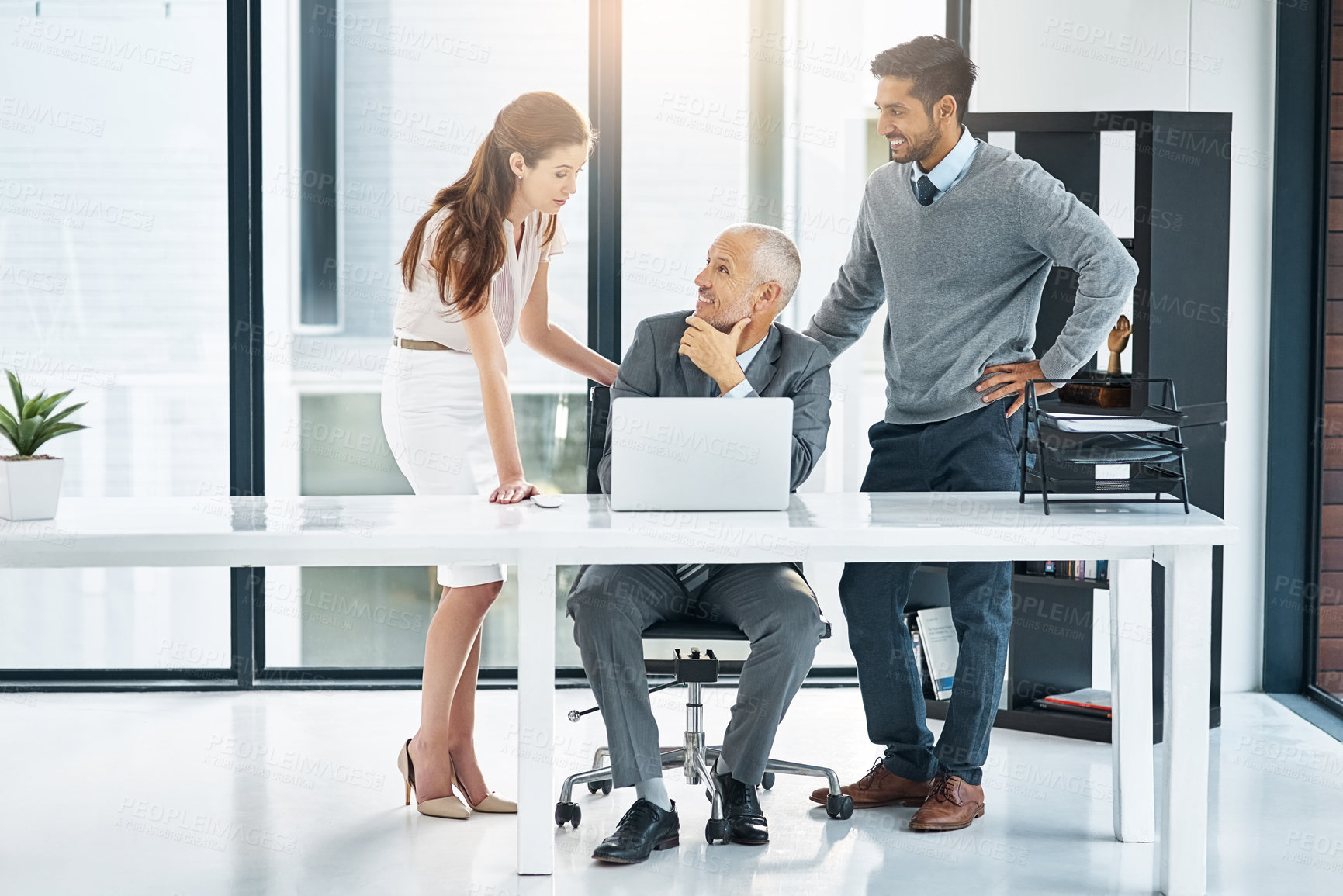Buy stock photo Full length shot of three businesspeople using a laptop in the office