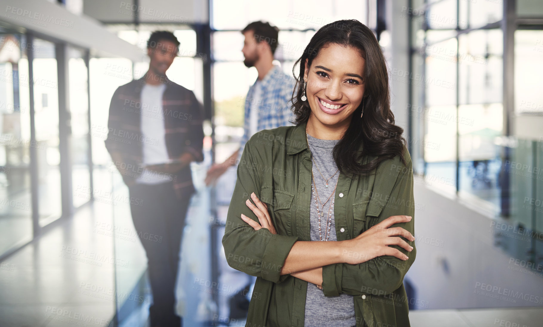 Buy stock photo Portrait of a young designer standing in a modern office with colleagues in the background