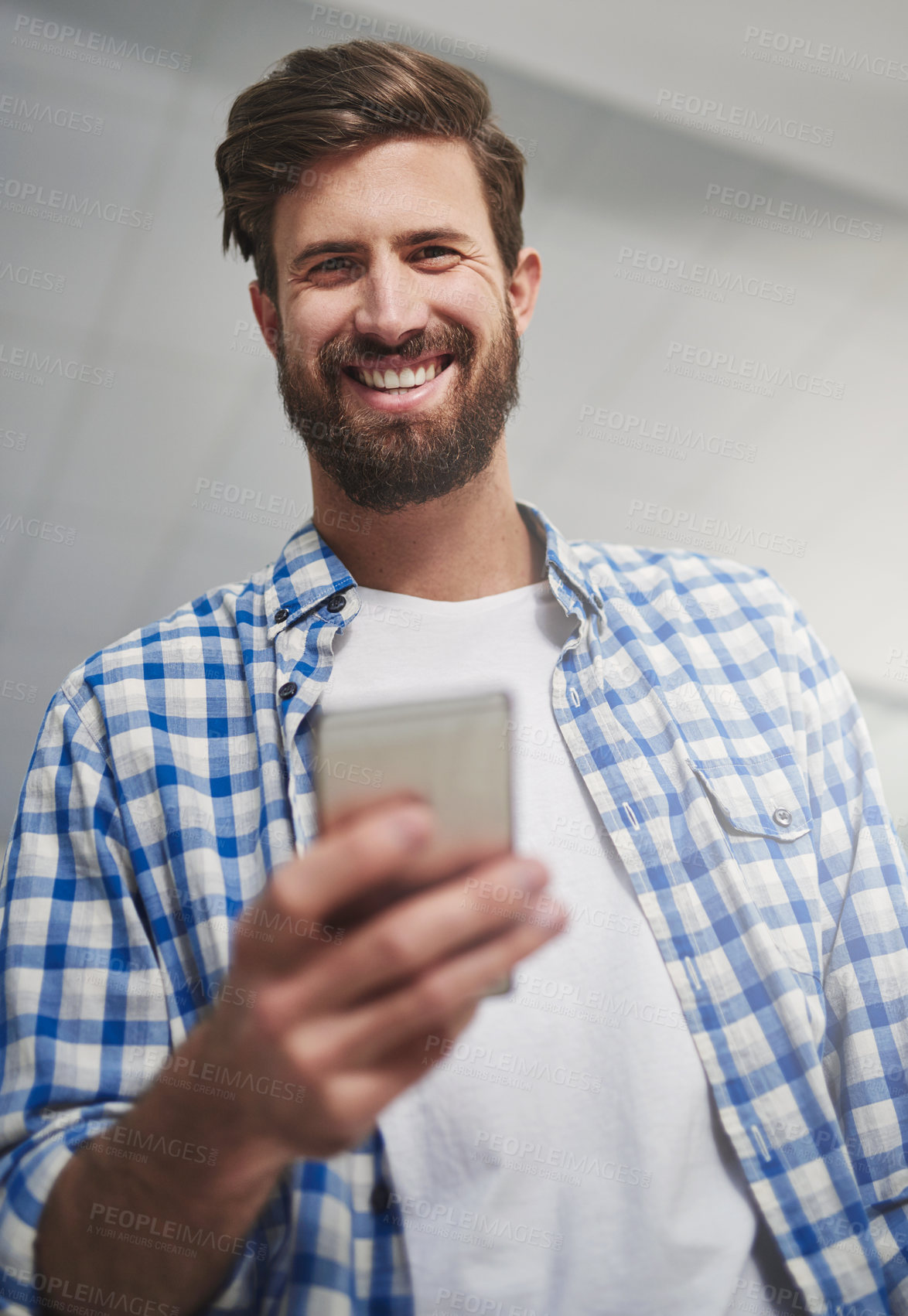 Buy stock photo Portrait of a young designer using a cellphone in a modern office