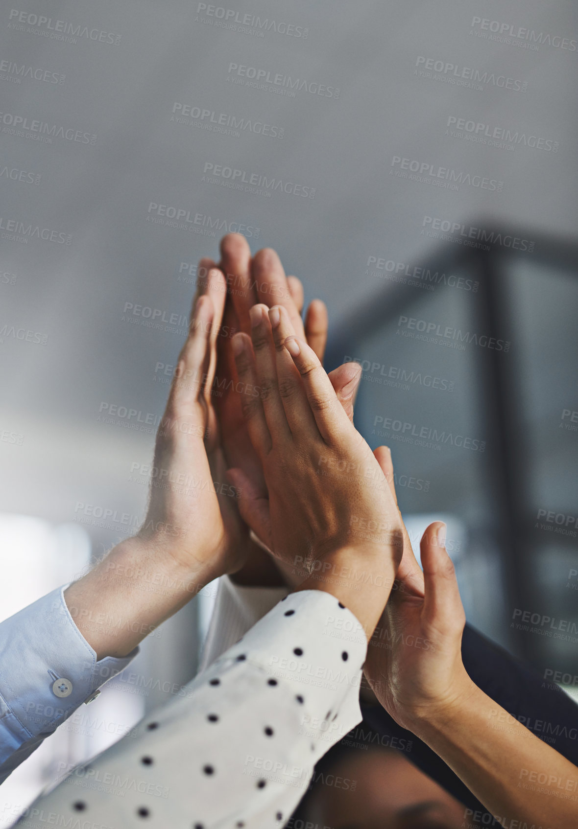 Buy stock photo Low angle shot of a group of unrecognizable coworkers high fiving in the office