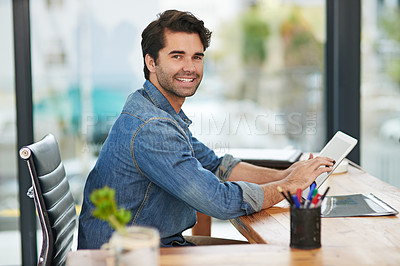 Buy stock photo Cropped shot of a creative businessman working on his tablet at his desk