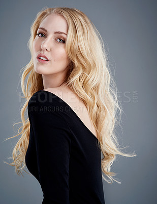 Buy stock photo Studio portrait of an attractive young woman with beautiful long blonde hair posing against a gray background