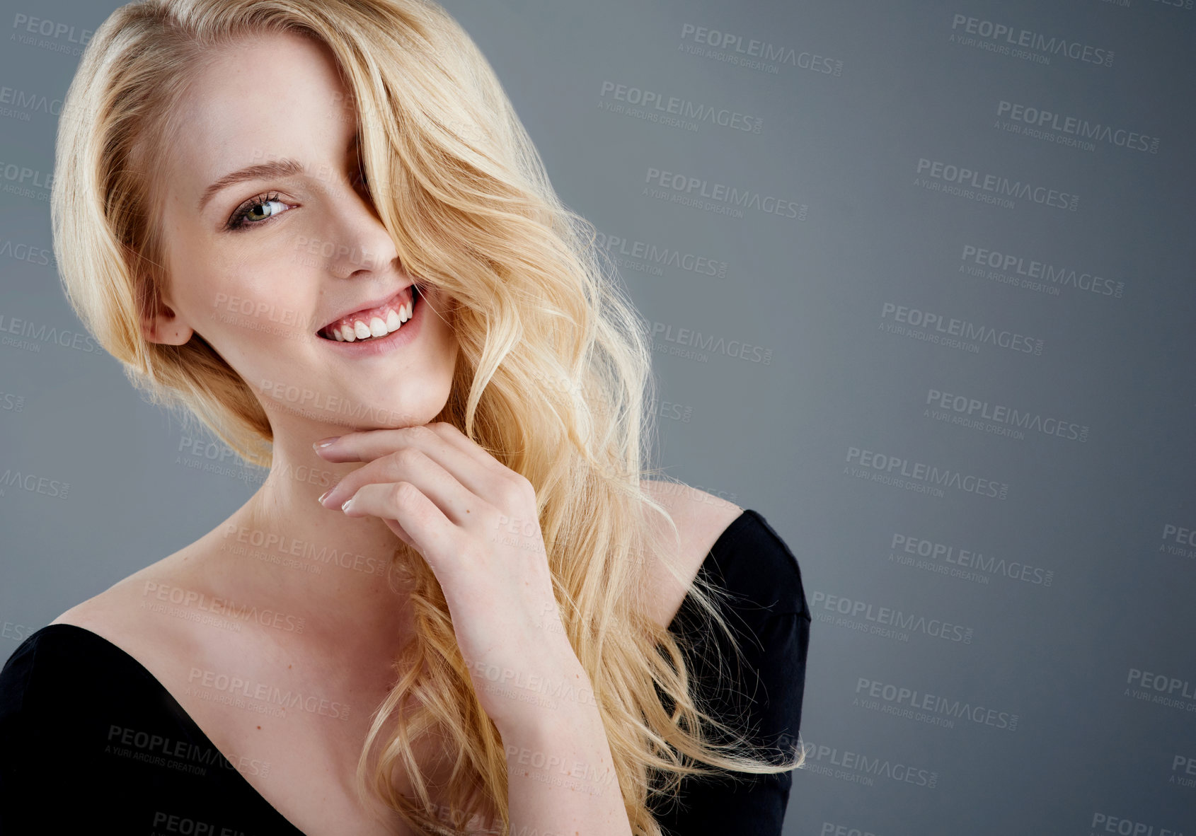 Buy stock photo Studio portrait of an attractive young woman with beautiful long blonde hair posing against a gray background