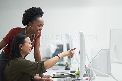 Buy stock photo Cropped shot of a creative businesswoman showing her colleague something on her computer