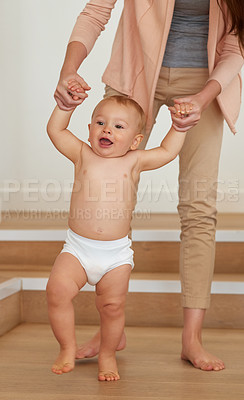 Buy stock photo Cropped shot of a mother helping her baby boy learn to walk at home