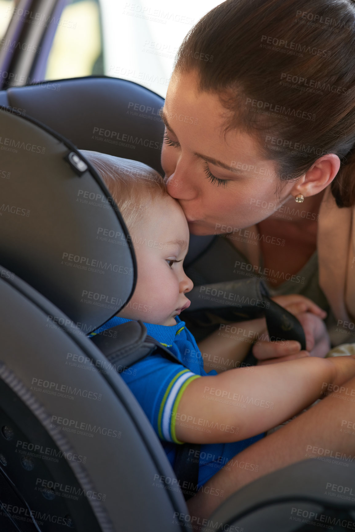Buy stock photo Cropped shot of a mother kissing her baby boy sitting in a car seat