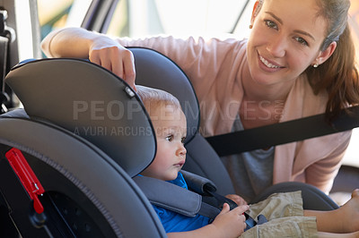 Buy stock photo Portrait of a mother fastening her baby boy safely in a car seat