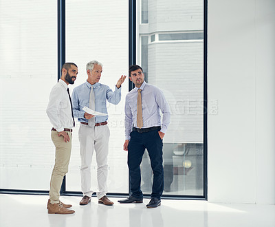 Buy stock photo Shot of business colleagues having a discussion in an empty office