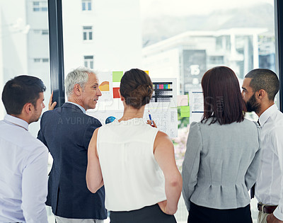 Buy stock photo Cropped shot of a group of businesspeople looking at graphs together