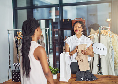 Buy stock photo Cropped shot of a shop assistant packaging a purchase for a customer