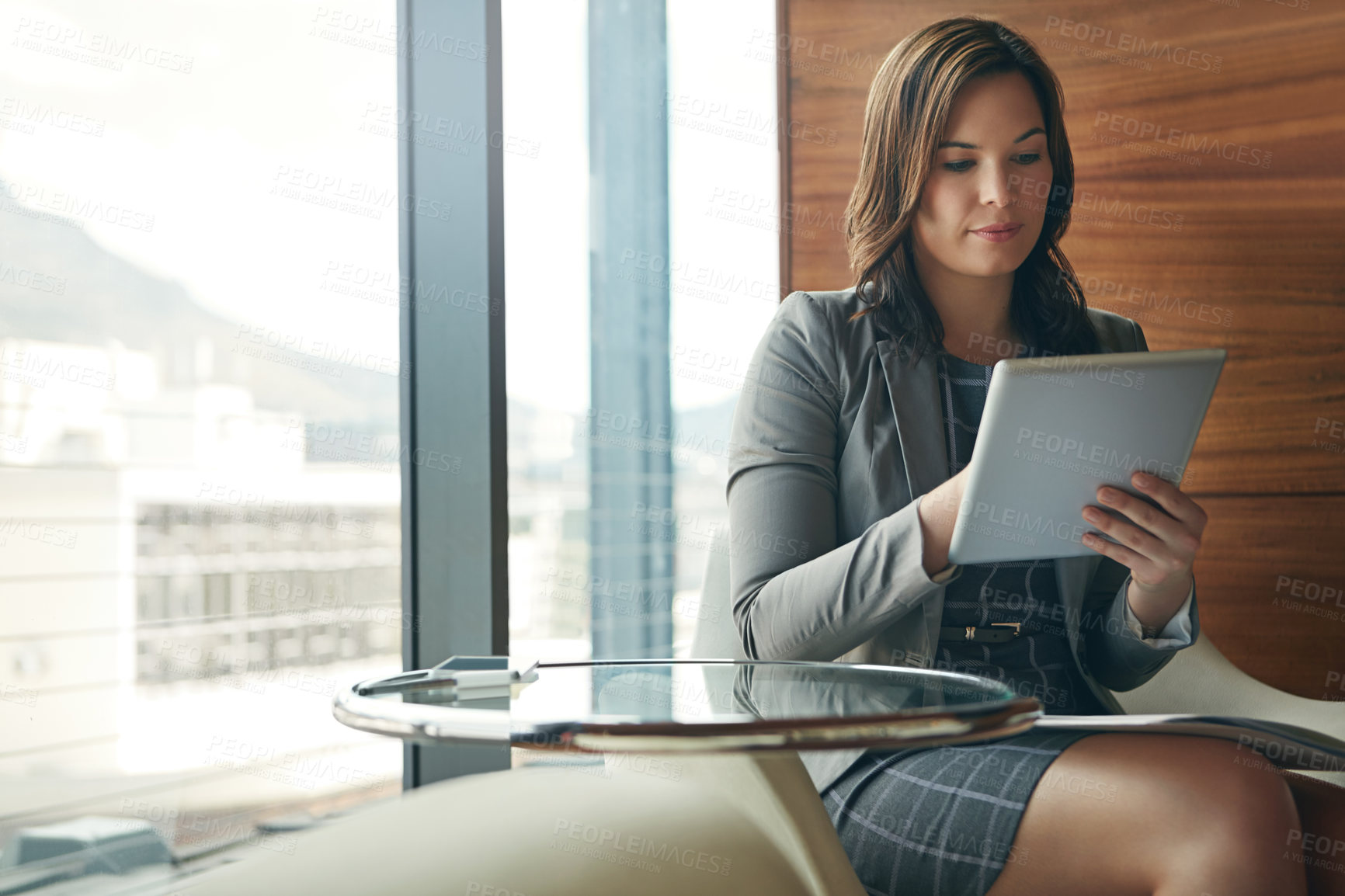 Buy stock photo Cropped shot of a young businesswoman sitting in her office and working on her tablet