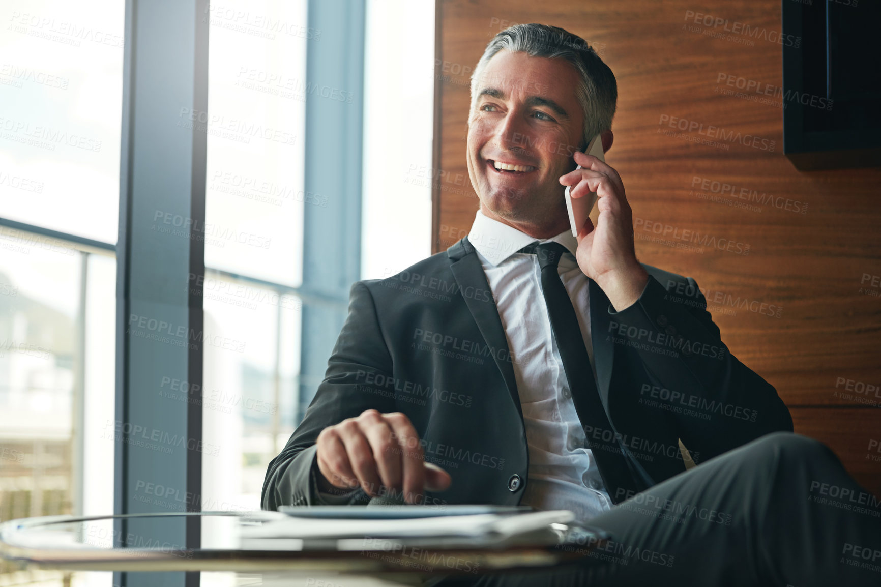 Buy stock photo Cropped shot of a businessman answering a phonecall while sitting in his office