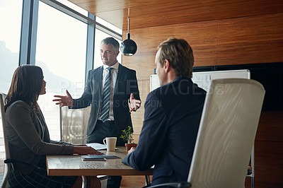 Buy stock photo Shot of a team of professionals having a meeting in a boardroom