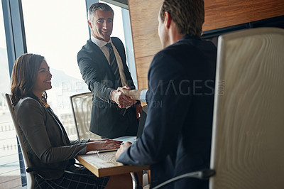 Buy stock photo Shot of two businessmen shaking hands during a meeting in the boardroom