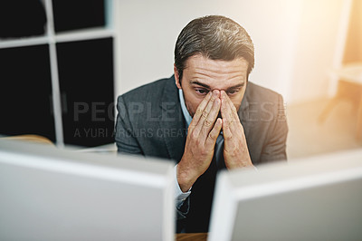 Buy stock photo Shot of a mature businessman looking stressed out at his desk