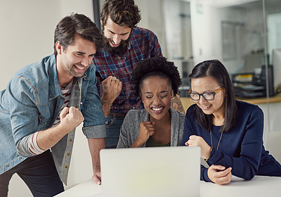 Buy stock photo Shot of a group of designer gathering to look at something on a laptop