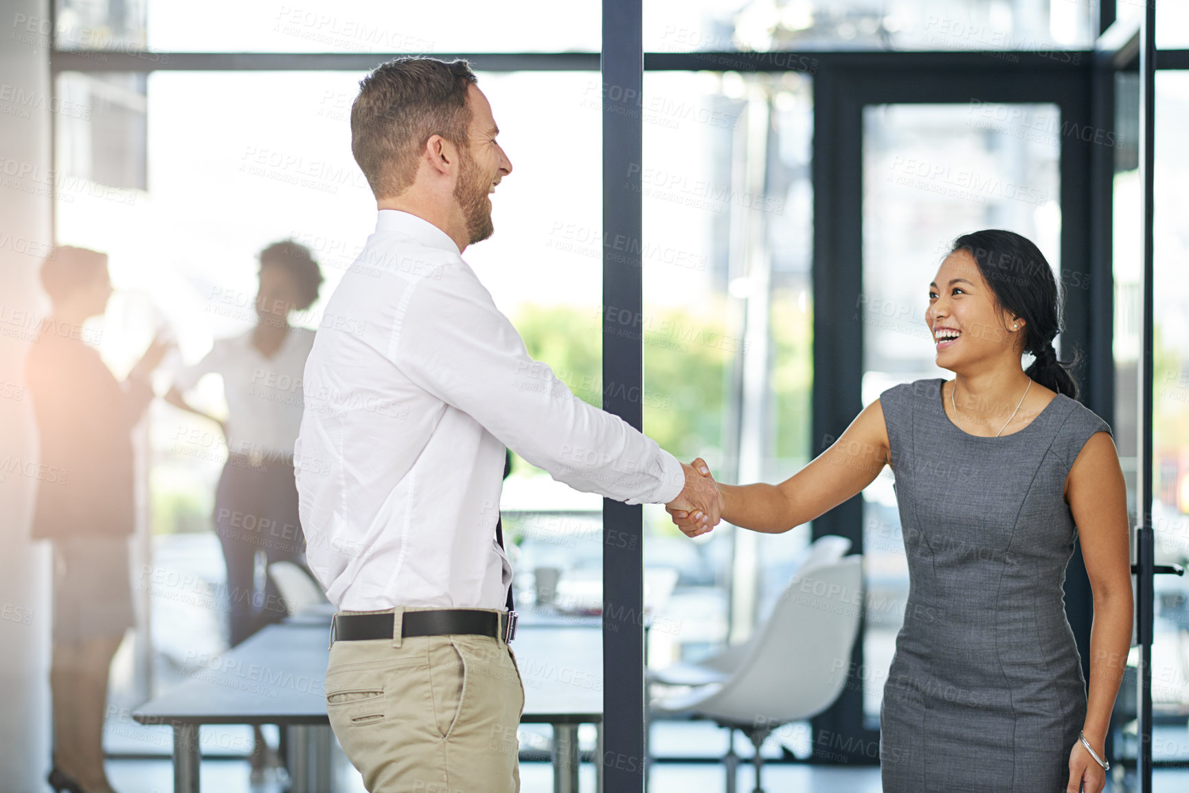 Buy stock photo Cropped shot of two colleagues shaking hands outside the boardroom before their presentation