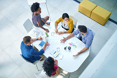 Buy stock photo High angle shot of a group of colleagues meeting in the boardroom