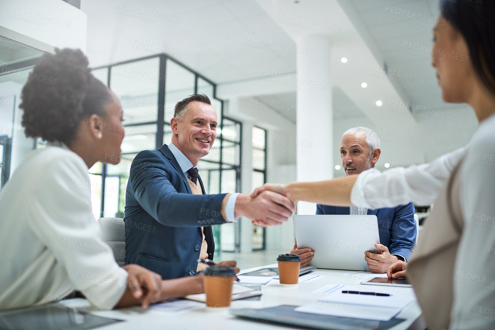 Buy stock photo Cropped shot of businesspeople shaking hands during a meeting in a modern office
