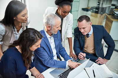 Buy stock photo Cropped shot of businesspeople working together on a laptop in a modern office