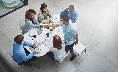 Buy stock photo High angle shot of young businesspeople shaking hands during a meeting