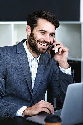 Buy stock photo Cropped shot of a young businessman talking on a cellphone while working on a laptop in a modern office
