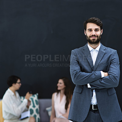 Buy stock photo Portrait of a young businessman standing in a modern office with colleagues in the background