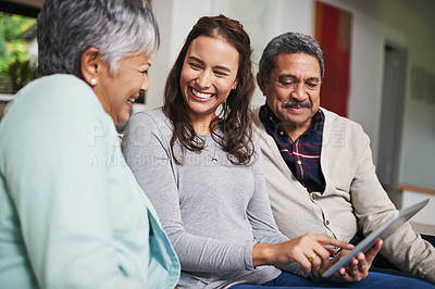Buy stock photo Senior parents, female person and tablet with smile in lounge for e commerce or bonding with tech. Family, home and mature people with young, woman and happy for togetherness on couch in community