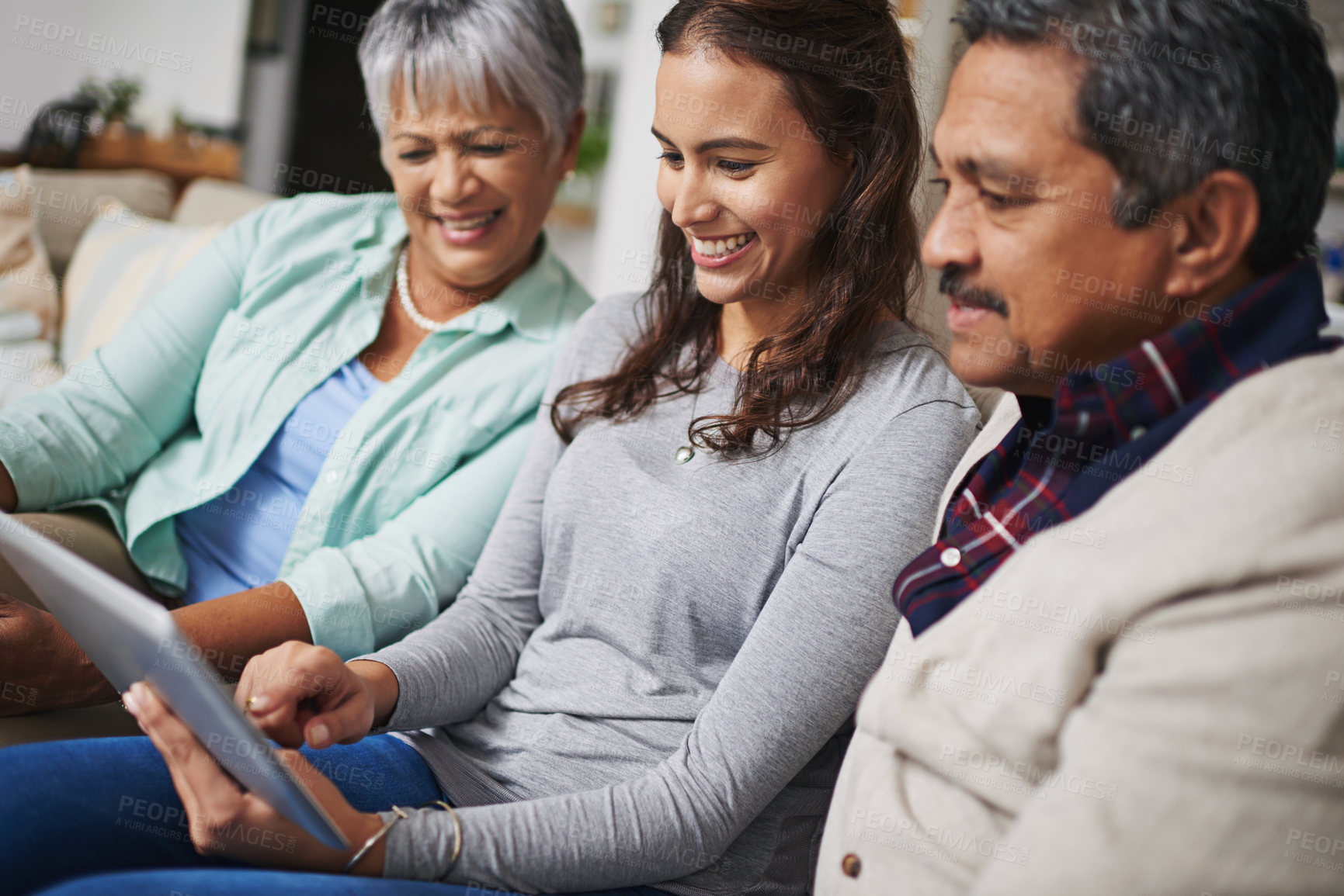 Buy stock photo Happy, tablet and woman teaching parents networking on internet, mobile app or website on sofa. Smile, bonding and senior man and woman learning digital technology with female person in living room.