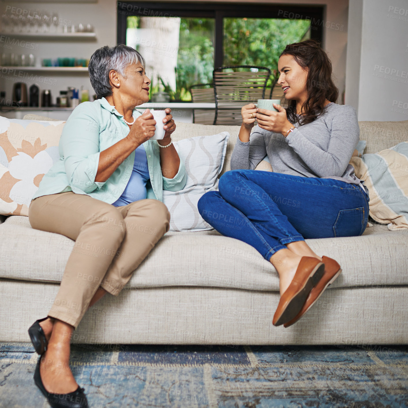Buy stock photo Relax, coffee and mother with daughter on sofa in living room for bonding, conversation and happiness. Smile, chat and discussion with women talking in family home for generations, reunion and break