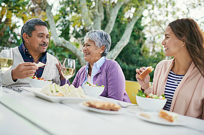 Buy stock photo Cropped shot of a family enjoying lunch and wine together outside