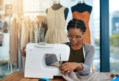 Buy stock photo Cropped shot of a young fashion designer using a sewing machine in her workshop