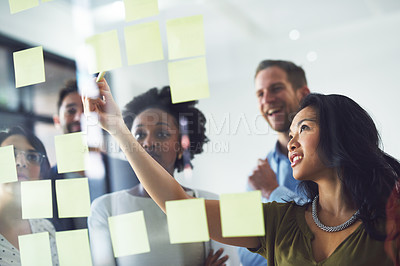 Buy stock photo Cropped shot of a group of businesspeople working on a glass wall in the office