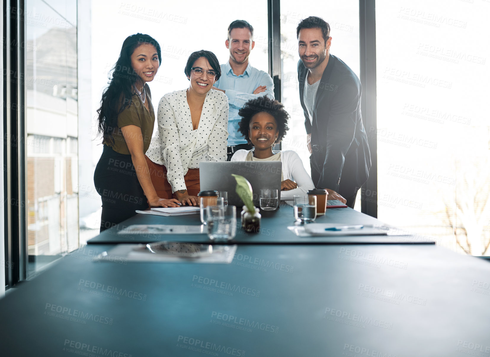 Buy stock photo Cropped portrait of a group of businesspeople gathered around a laptop in the office