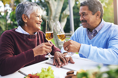 Buy stock photo Shot of a happy older couple sharing a toast outdoors
