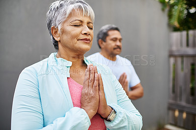 Buy stock photo Shot of an older couple meditating together outdoors