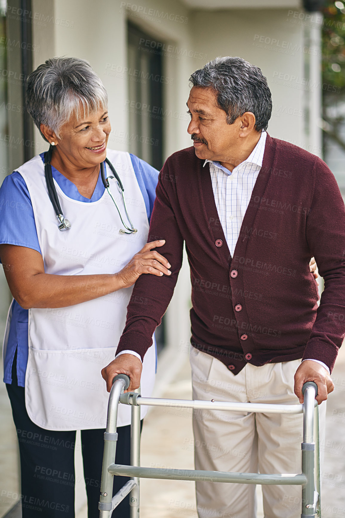 Buy stock photo Nurse, person with disability and walker with talking at retirement home or outside, care and stethoscope. Disabled retiree and medical or outdoors for support or plan, healthcare or conversation