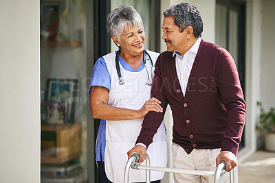 Buy stock photo Cropped shot of a nurse going for a walk with her senior patient and his walker outside
