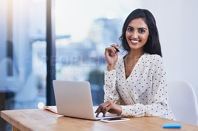 Buy stock photo Portrait of a beautiful young businesswoman working on a laptop in a modern office